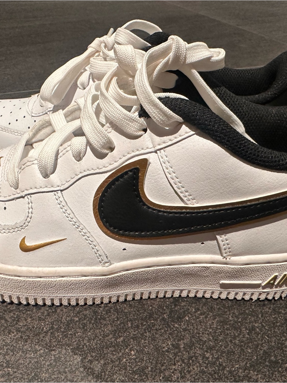 Nike White Sneakers with Black and Gold Swoosh